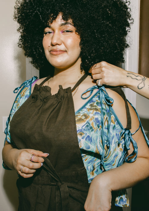 A chef puts on a black Hosting Apron