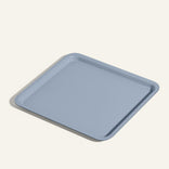 A light blue, square tray with rounded corners and raised edges, placed on a light-colored surface.