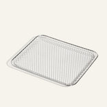 A rectangular wire mesh cooling rack with rounded corners, placed on a light-colored surface.