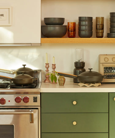 our place black cookware and dinnerware on counter and stove