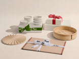 Collection of ceramic and wooden items with 'Our Place' branding on a beige background