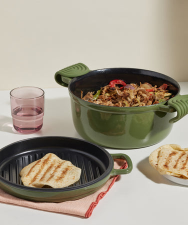 green cast iron perfect pot and hot grill serving fajitas and rosa drinking glass