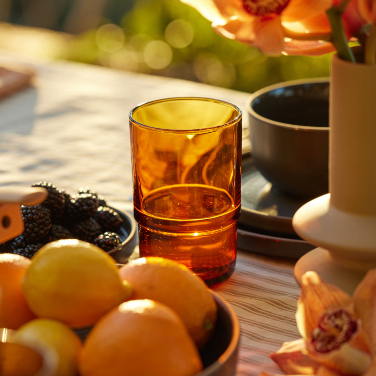 Orange Tall Night + Day Glass next to fruit bowls on a table