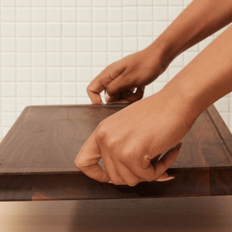 woman holding walnut cutting board