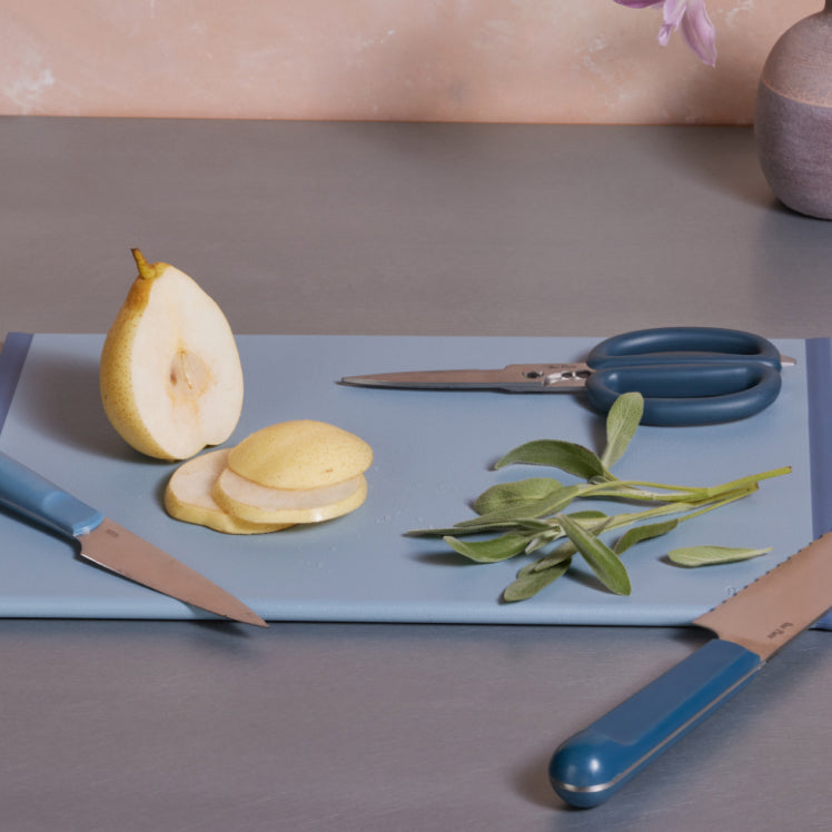Blue Daily Board with Sliced pear, cutting shears and knives