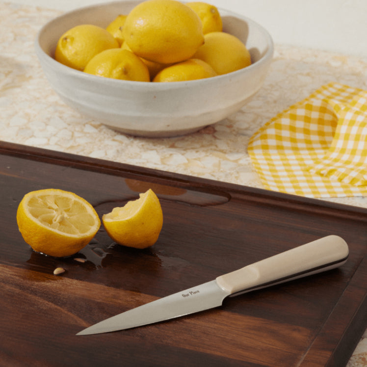 beige precise paring knife on walnut cutting board with lemons