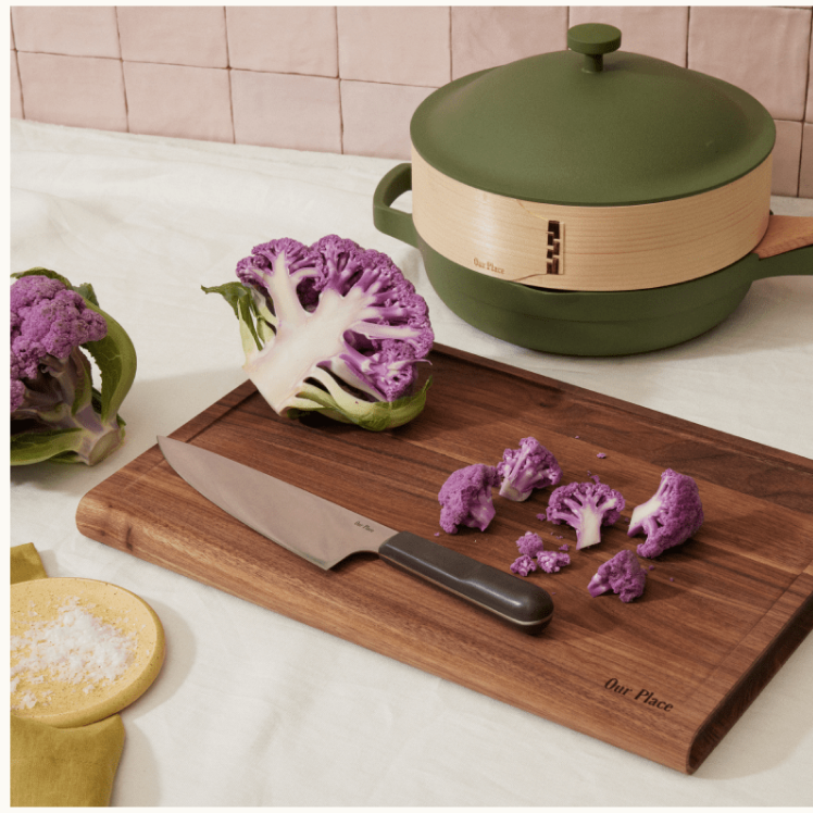 Black Everyday Chef's Knife on top of the Walnut Cutting Board with cauliflower