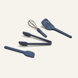 Four blue Mini Utensil Essentials—a spatula, tongs, whisk, and slotted turner—are arranged on a plain off-white background.