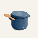 The Rice Cooker features a blue finish, digital display on the lid, wooden spoon resting on its handle, and the Our Place logo displayed on the front.