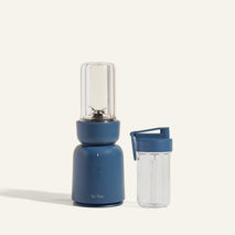 Blue portable blender with a clear container on a white background