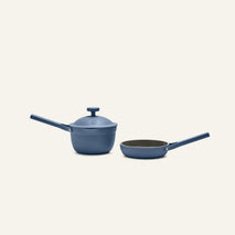 The Tiny Cookware Duo, featuring a blue saucepan with lid and a matching blue frying pan, both with long handles, is displayed on a plain light background.