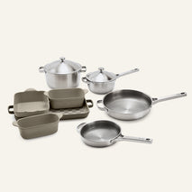 Titanium Pro Cookware + Bakeware Set (2.0) featuring a collection of stainless steel cookware, including two pots with lids and two frying pans, alongside a set of gray ceramic bakeware pans.