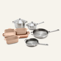 Titanium Pro Cookware + Bakeware Set (2.0) featuring stainless steel cookware with lids, three peach-colored ceramic bakeware dishes, and a matching rectangular tray.