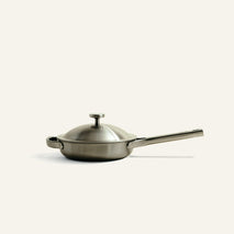 A metallic, low-profile Titanium Always Pan Pro 20 cm (2.0) stainless steel skillet with a lid and a long handle.