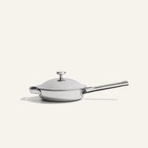 A Titanium Always Pan Pro 20 cm (2.0) non-toxic stainless steel skillet with a long handle, short side handle, and a light-colored lid.