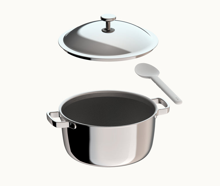 A stainless steel pot with its lid hovering above and a white kitchen spoon to the side.