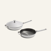 A white lidded Titanium Pro Always Pan Duo (2.0) and an open stainless steel pan.