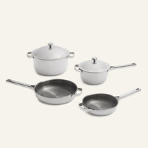 A Titanium Pro Cookware Set (2.0) featuring two lidded stainless steel pots and two frying pans with metallic handles.
