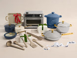 Collection of kitchenware including pots, pans, and utensils on a neutral background with 'Our Place' branding.