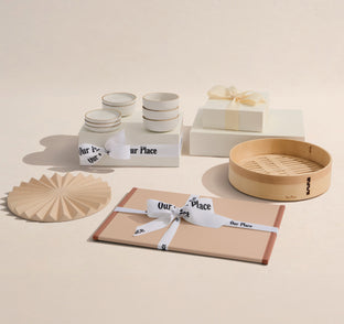 Set of kitchenware items including bowls, jars, and a bamboo steamer on a beige background.