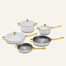 Titanium Pro Cookware Set+ (2.0) featuring five stainless steel pieces with gold-toned handles and lids.
