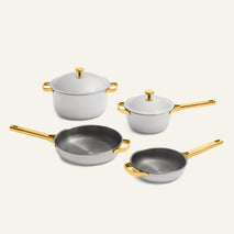 Titanium Pro Cookware Set (2.0) featuring two grey pots with lids and two grey frying pans, all with metallic gold handles.