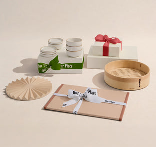 Set of kitchenware items including bowls, jars, and a bamboo steamer on a beige background.