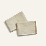 Two beige textured towels on a white background