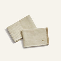 Two beige textured towels on a white background