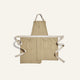 Beige apron with white straps on a light beige background