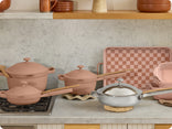 pink ultimate cookware set and chrome titanium always pan pro on counter and stove