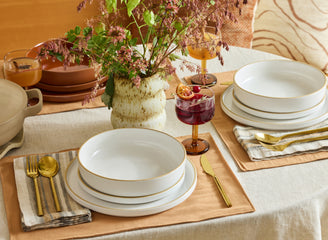 white dinner bowls, salad plates, and dinner plates stacked on table