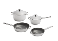 Four-piece stainless steel cookware set including two lidded pots, one lidded saucepan, and two frying pans, arranged on a clean white background.
