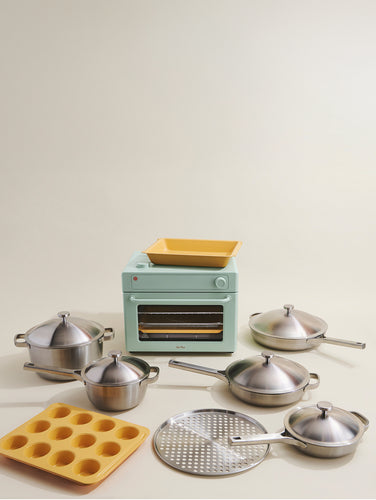 kitchen set with toaster, pots, pans, and a muffin tray on a light gray background