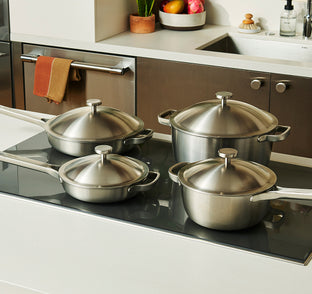 Set of stainless steel pots and pans on a kitchen stove