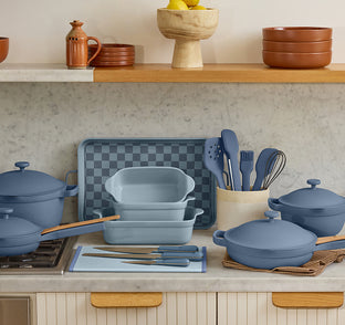 Blue kitchenware set on a countertop with a neutral background
