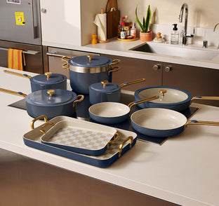 Set of blue cookware with gold handles on a kitchen counter