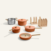 Set of orange cookware including pots and pans on a white background