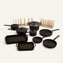 Set of black cookware including pots, pans, and skillets on a white background