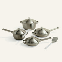 Set of stainless steel cookware with lids on a white background