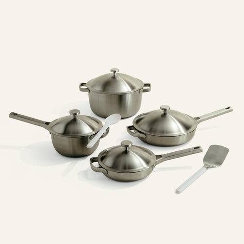 Set of stainless steel cookware with lids on a white background