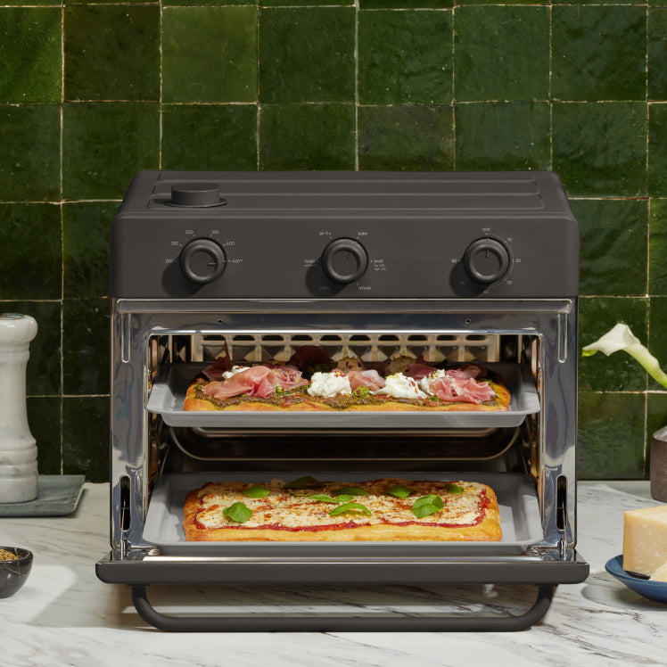 black large wonder oven on counter cooking pizza on two trays