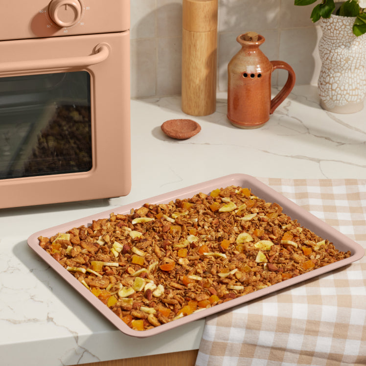 pink large wonder oven tray on counter with baked granola