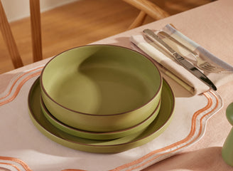 green dinner bowls, salad plates and dinner plates on table