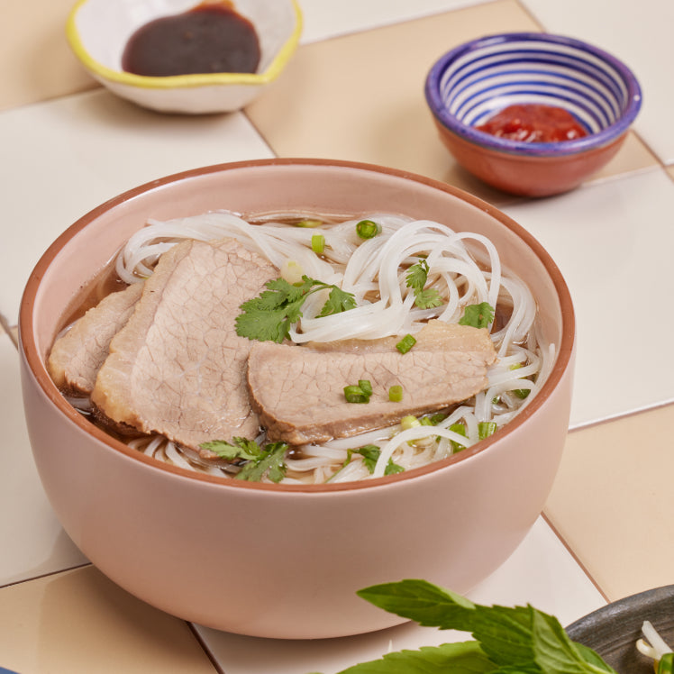 pink soup bowl on counter with pho