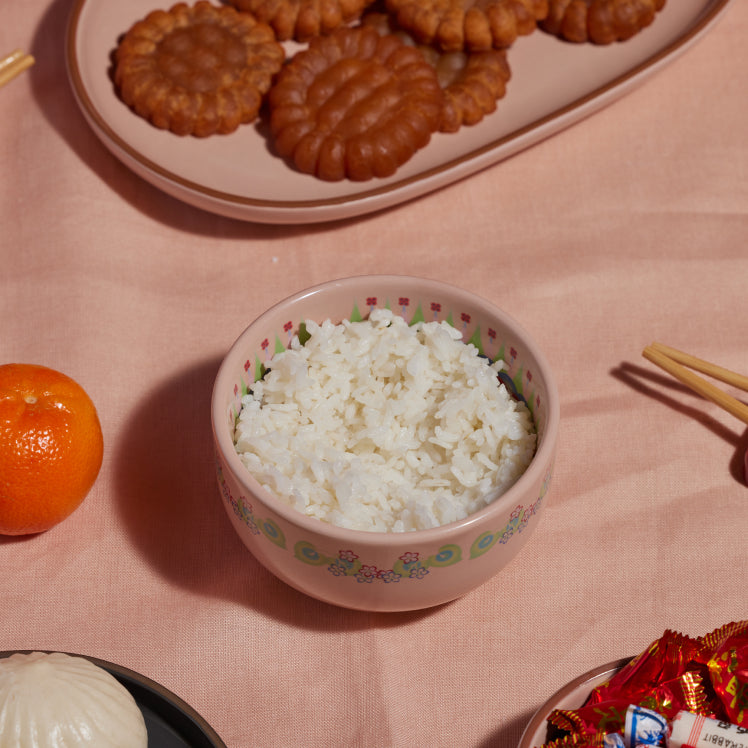 pink rice bowl set with food on table