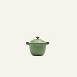The Petite Perfect Pot, featuring a matte green finish, two side handles, and a matching lid, is displayed against an off-white background.