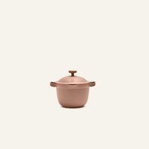 The Petite Perfect Pot, a matte pink Dutch oven with a lid and side handles, is centered on a plain light background.