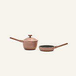The Tiny Cookware Duo features a lidded saucepan and an open frying pan with matching long handles in a matte rose gold finish, set against a plain light background.