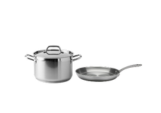 A stainless steel pot with a lid and a stainless steel frying pan are placed side by side on a plain white background.